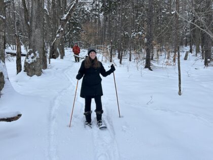 woman and man snowshoeing thru the forest