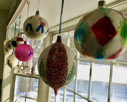 antique, glass Christmas balls hanging in a window